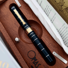 Load image into Gallery viewer, Front view of the rollerball pen with the cap on, arranged inside the presentation box.