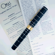 Load image into Gallery viewer, Side view of the fountain pen with the cap on, laid on the included documents.