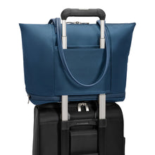 Load image into Gallery viewer, Briggs & Riley Rhapsody Expandable Tote - Shown in Navy
Image of Attachment Feature, allowing this tote to ride along the telescoping handles of most carry-on trolley bags.
Dimensions: 13.5 x 19.5 x 7.5 in / 34.4 x 49.5 x 19.1 cm