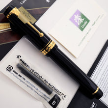 Load image into Gallery viewer, A Pilot Custom Black Urushi Fountain Pen with a gold nib and Urushi lacquer finish, displayed alongside its packaging.