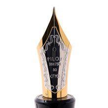 Load image into Gallery viewer, Close up to the fountain pen nib. it is bi-colored. Engraved decorations frame the following text: PILOT 18K-750 <FM>. FM stands for a fine medium point, but each will vary on availability.