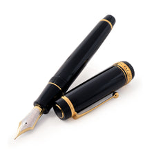 Load image into Gallery viewer, Angled view of the fountain pen arranged with the cap next to it.
