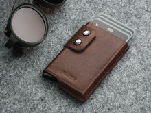 Load image into Gallery viewer, A brown wallet with double button snap closure and six cards peeking from the top.