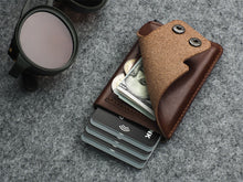 Load image into Gallery viewer, Angled front view of the wallet with the flap lifted. Six credit cards, cash, and two coins are tucked in the compartments.
