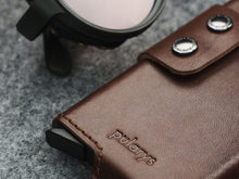 Load image into Gallery viewer, Close up to the bottom of the brown wallet with pularys logo embossing.