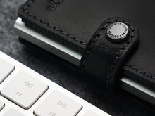 Load image into Gallery viewer, Close up to the snap closure strap next to a keyboard.