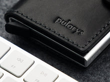 Load image into Gallery viewer, Close up to the pularys logo embossing on the black wallet