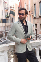 Load image into Gallery viewer, A young man holding a black wallet in an urban setting.