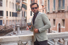 Load image into Gallery viewer, A young man holding a black wallet on an urban setting.