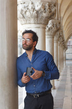 Load image into Gallery viewer, A young man holding his wallet.