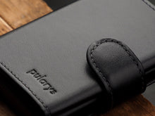 Load image into Gallery viewer, Close up to the black wallet with pularys embossing.