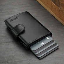 Load image into Gallery viewer, Angled view of the black wallet with six credit cards peeking from the lever compartment.