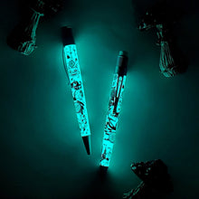 Load image into Gallery viewer, The pen and pencil glowing in the dark, surrounded by mushroom figures.