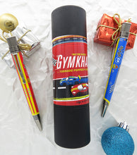 Load image into Gallery viewer, The red and blue gymkhana pens arranged on a white background with the gift tube and Christmas tree decorations.