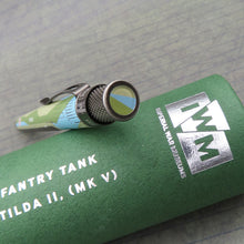 Load image into Gallery viewer, The pen sits atop the green presentation tube, the pen shows the top disc which is the Imperial War Museums logo with a gray background.