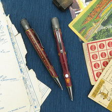 Load image into Gallery viewer, Maroon pens with satin silver accents on a textured blue surface with vintage cards and papers.