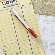 Load image into Gallery viewer, Side view of the rollerball pen. Laid on papers with printed graphics.