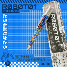 Load image into Gallery viewer, The Aisha pen leaning on a gift tube. Set on a blue background with graphics, text, and a grid.