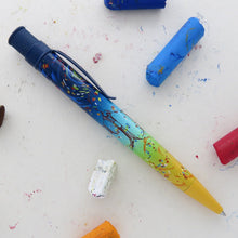 Load image into Gallery viewer, Side view of the pen with pieces of oil pastel on a white background.