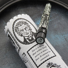 Load image into Gallery viewer, Angled close up to the top of the Picture of Dorian Gray pen resting on the matching gift tube. An hour glass icon and the initials DG are shown on the pen's top disk.