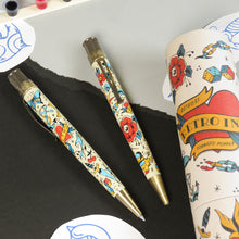 Load image into Gallery viewer, Two pens arranged with a gift tube, tattoo designs and ink.