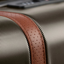 Load image into Gallery viewer, Close up to a tan leather strap attached to the suitcase.