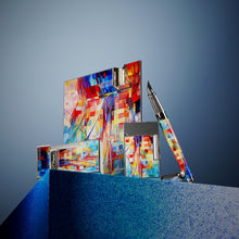 Load image into Gallery viewer, The image shows some of the items available in the Graff'ty Collection, including the ashtray, fountain pen, the biggy lighter, and the Line 2 Lighter, set on a blue stand with a blue background