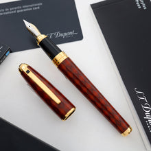 Load image into Gallery viewer, The fountain pen with a red and brown argyle patterned design and gold trims, shown with its cap removed and placed beside it on a white surface, with branded black cards in the background.