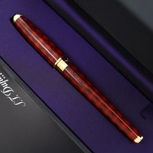 Load image into Gallery viewer, A close-up of the rollerball pen with gold accents, resting diagonally on a purple-lined presentation box.