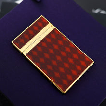Load image into Gallery viewer, The back of the lighter with a red and brown argyle-patterned body, on a purple surface.
