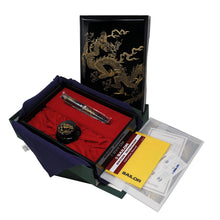 Load image into Gallery viewer, A limited edition Sailor fountain pen with a black and gold design, displayed in an open case alongside an inkwell, a cleaning cloth, and a set of documents.