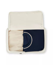 Load image into Gallery viewer, The packing bag shown unzipped and filled with folded clothes.