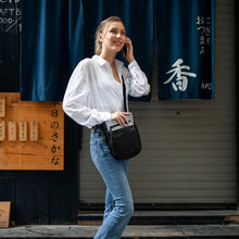 Load image into Gallery viewer, A young woman carrying the bag while speaking on the phone.