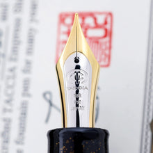 Load image into Gallery viewer, Close up to the fountain pen nib. It is two-toned, and engraved with the Taccia logo, and the text 18K 750 Japan