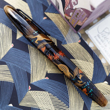 Load image into Gallery viewer, Side view of the fountain pen with the cap on. Laid on a paper printed with line patterns.