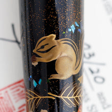 Load image into Gallery viewer, Close up to the squirrel holding an acorn.