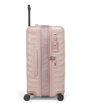 Load image into Gallery viewer, Side panel view of the suitcase showing the expandable feature unzipped, a grab handle, a contact information tag, and a TSA approved three digit combination lock.