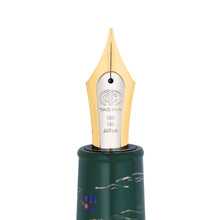 Load image into Gallery viewer, Close up to the fountain pen nib. This one is a bi-colored yellow and white gold nib made of 18K gold. It is engraved with the Taccia logo, 18K, 750, JAPAN.