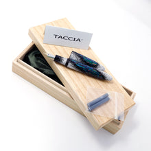Load image into Gallery viewer, The fountain pen arranged with two blue ink cartridges, a small folded card with details, and the presentation box.