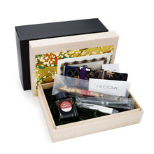 Load image into Gallery viewer, The Double Dragons Fountain Pen in its presentation box with the ink bottle, ink cartridge, documents, and boxes on a white background.