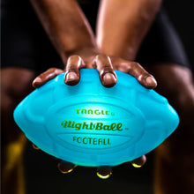 Load image into Gallery viewer, Two hands holding the lit up blue Nightball football on a dark background.