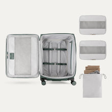 Load image into Gallery viewer, Interior view of the suitcase arranged with two packing cubes and a laundry bag.