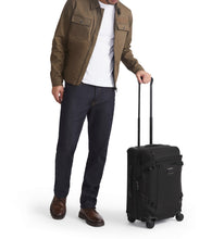 Load image into Gallery viewer, A young man holding the suitcase by the extended telescopic handle.