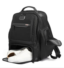 Load image into Gallery viewer, Angled front view of the backpack demonstrating a pair of shoes peeking from the bottom shoe compartment.