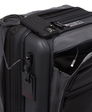 Load image into Gallery viewer, Angled close up to the top of the suitcase. The side panel above the tag features a USB plug to charge your mobile devices on the go. (Charging bank required, not included)