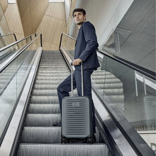 Load image into Gallery viewer, A young man wearing a suit, going up an escalator with the Airox Advanced Frequent Flyer Carry-On business case.
Dimensions:  22.8"H x 15"W x 9.4"D
Weight:           6.6 lbs.
Capacity:        44 L.