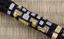 Load image into Gallery viewer, Close up to the barrel of the pen showing the diamonds, silver, and gold vermeil pieces with mythical creature designs.