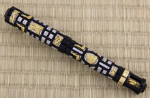 Load image into Gallery viewer, The Fountain Pen with the cap on. It is made of black lacquer with encrusted pieces of silver and gold vermeil . The silver pieces have a small pave of diamonds within them.