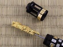 Load image into Gallery viewer, Close up to the bottom of the fountain pen. The black piece of the pen can be unscrewed to pull the gold vermeil dragon, which works as a piston.