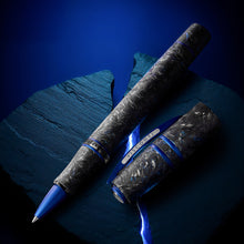 Load image into Gallery viewer, Uncapped rollerball pen on a dark blue surface,